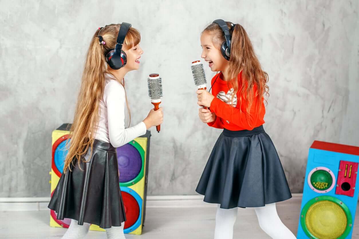 Two girls singing into hair brushes.