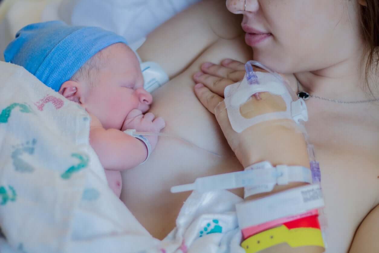 En mor som nettopp har hatt et keisersnitt som ammer sitt nyfødte barn.
