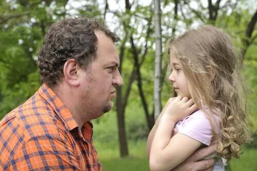 A father frowning at his young daughter.