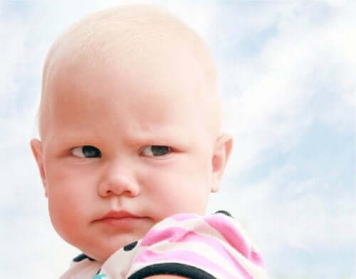 A baby girl looking suspiciously over her shoulder.
