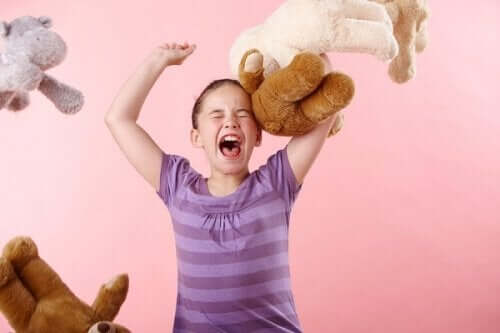A preteen girl having a temper tantrum and throwing her stuffed animals.