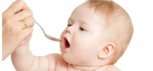 En kvinne som serverer en baby med en skje.