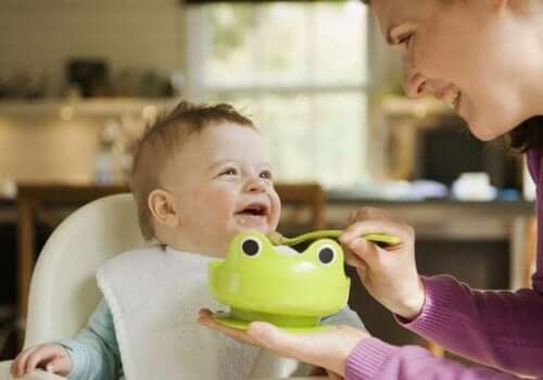 A mother spoon-feeding her baby.