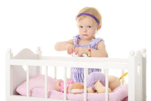 A toddler girl sitting in her crib.