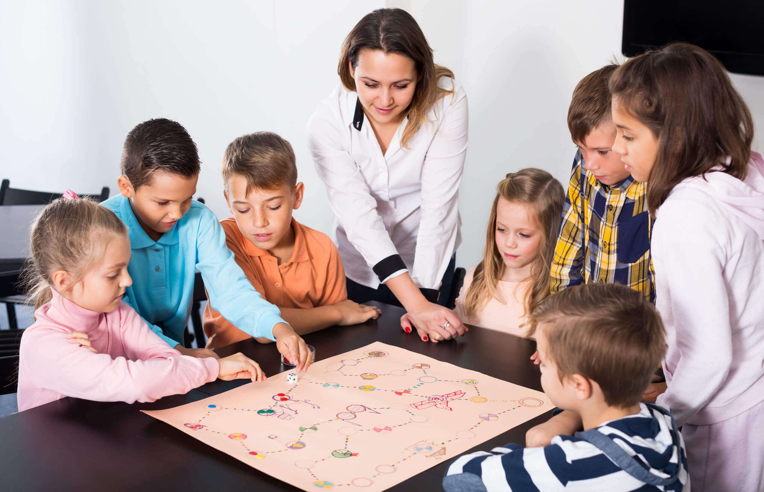 Children and their teacher playing a board game.
