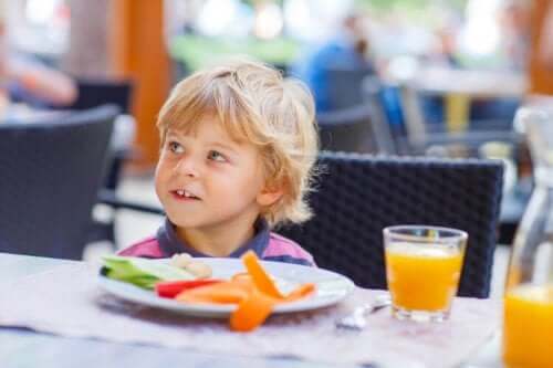 Ett litet barn sitter vid ett restaurangbord.
