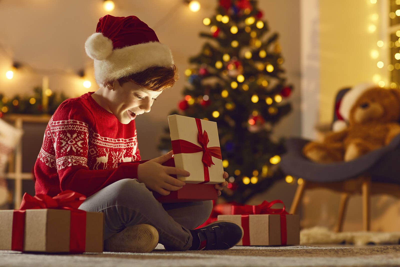 A young boy opening presents on Christmas morning.