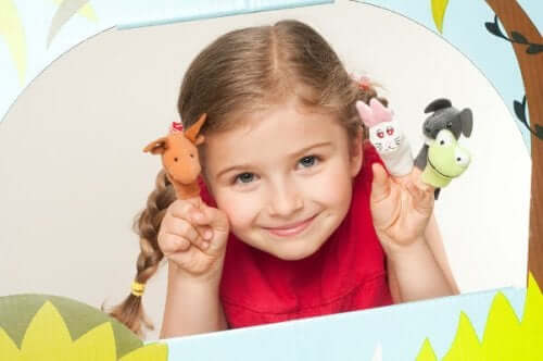 A little girl playing with finger puppets.