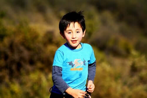 A young boy running outdoors.