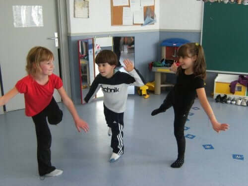 Three young children trying to balance on one foot.