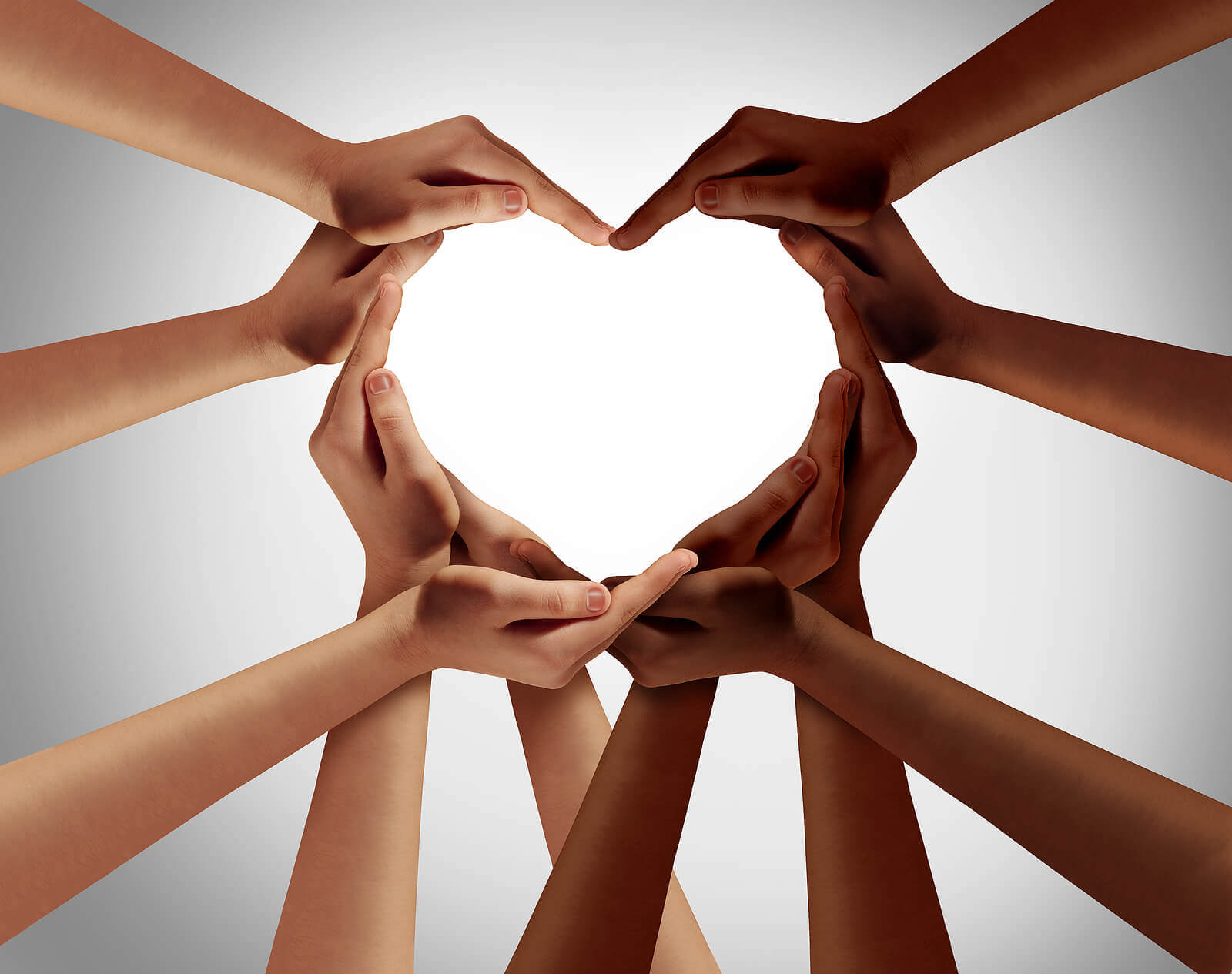 Light and dark-skinned hands forming a heart.