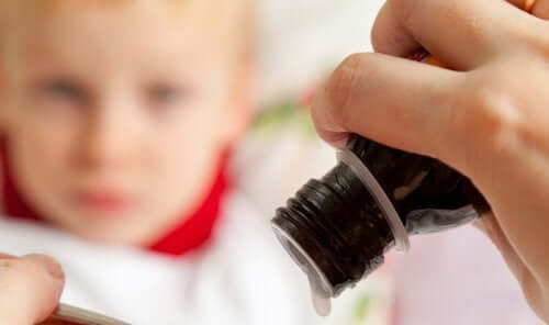 A woman pouring cough syrup for her son.