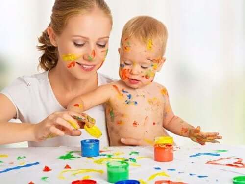 A mother and baby finger painting togther.