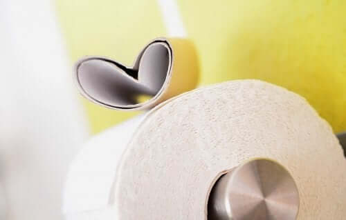 An empty toilet paper roll sitting on top of a full one.
