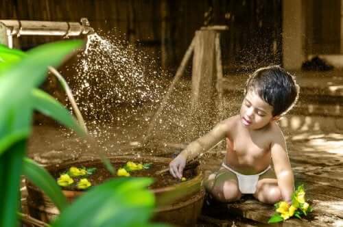 A boy in a diaper playing with water.
