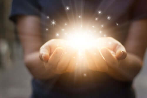 A glowing light coming out of a persons hands.