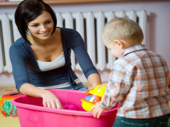 A mother and a toddler boy playing with toys.