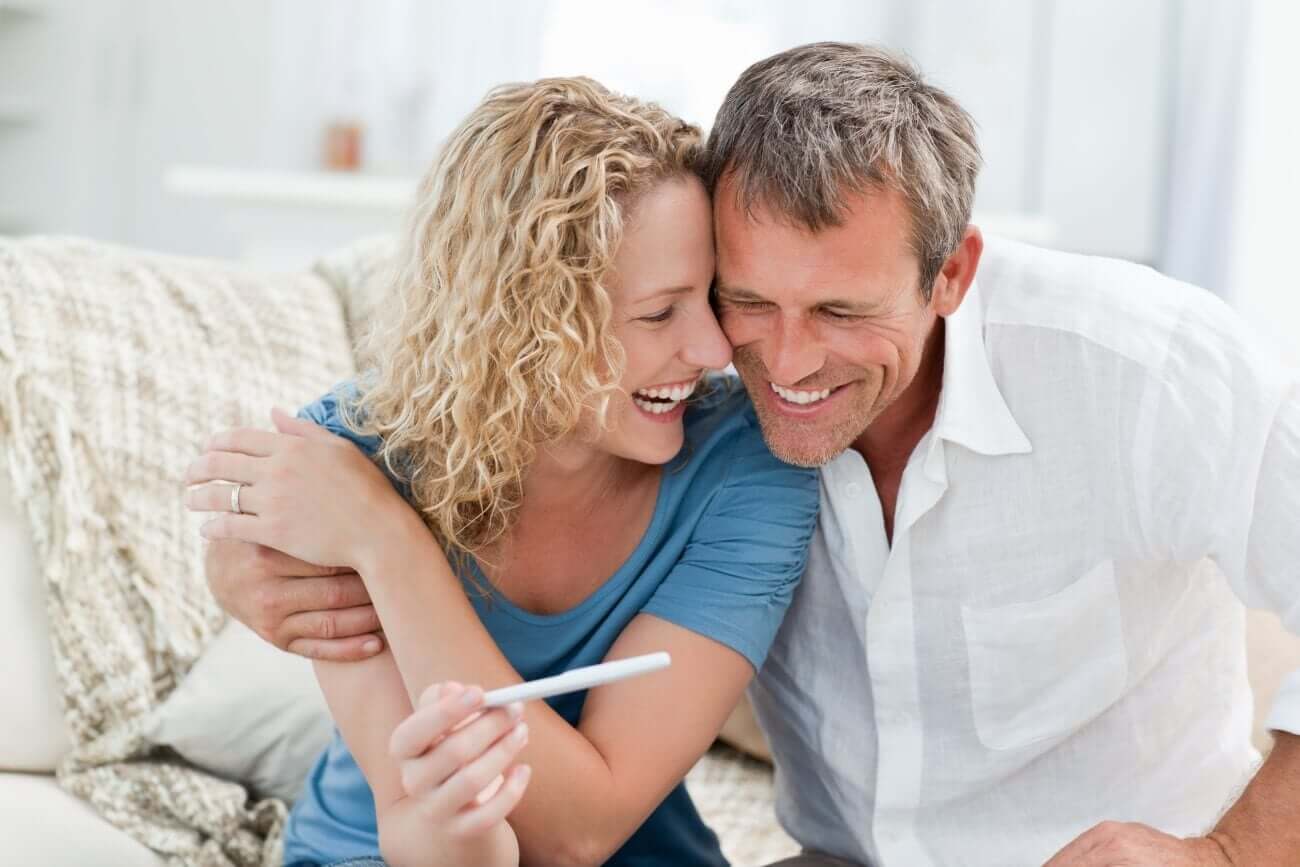 A happy couplel looking at a pregnancy test.