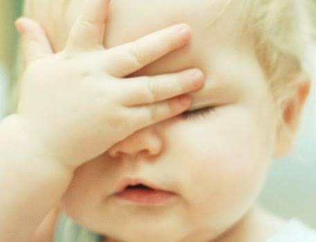 A baby with her hand on her face.