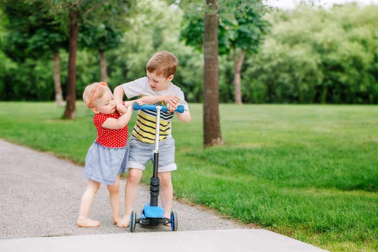 Siblings fighting over a scooter.