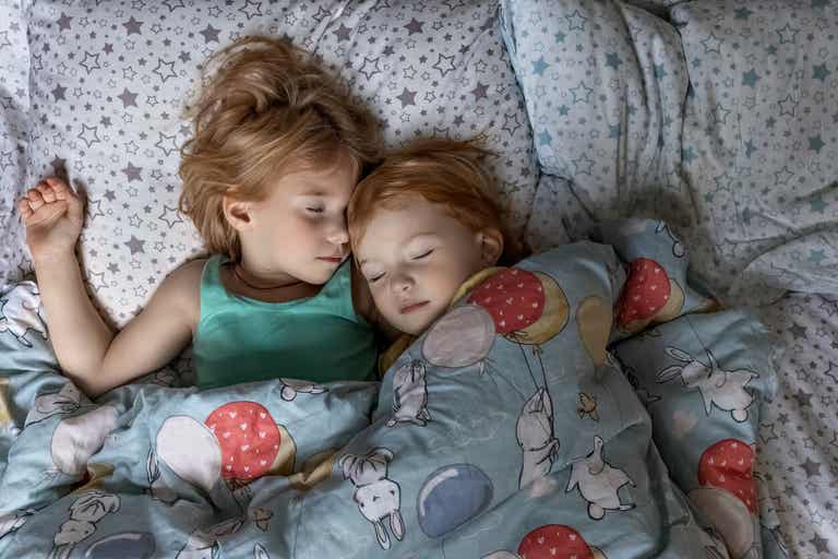 Siblings sleeping in the same bed.