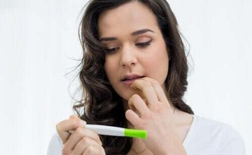 A teen looking at a pregnancy test.