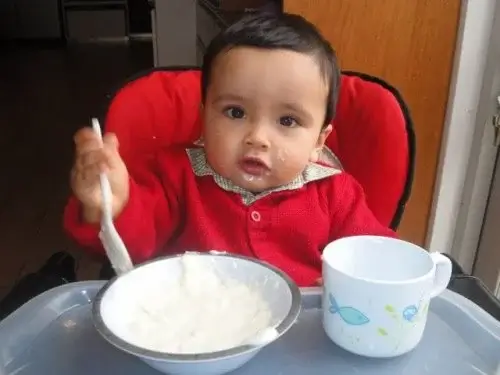 A baby eating rice.