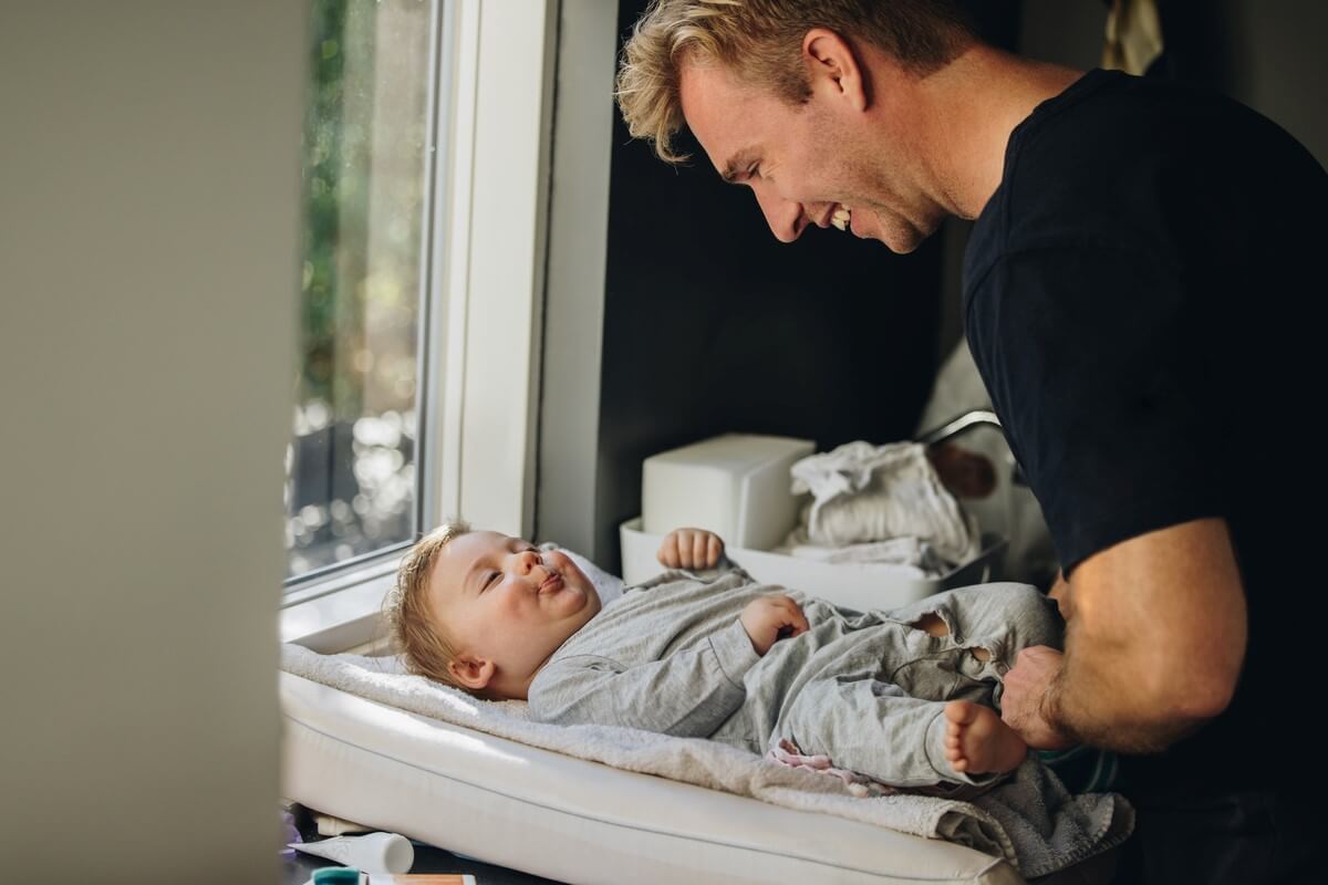 A father changing his baby's diaper.