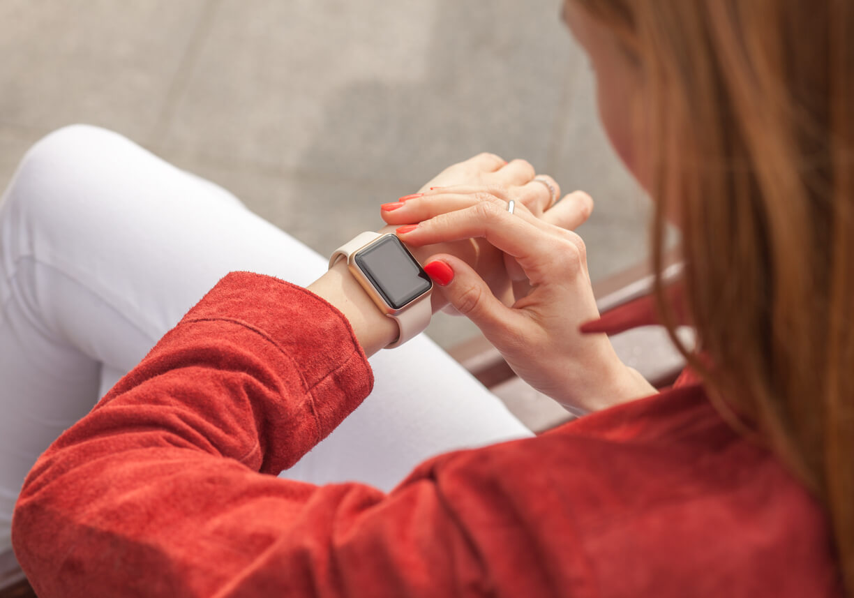 A woman looking at her smartwatch.