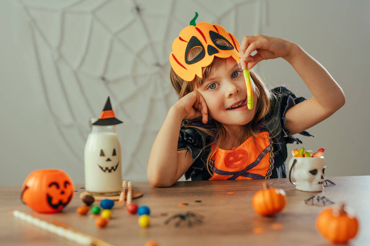 En liten jente som spiser halloween-godteri.