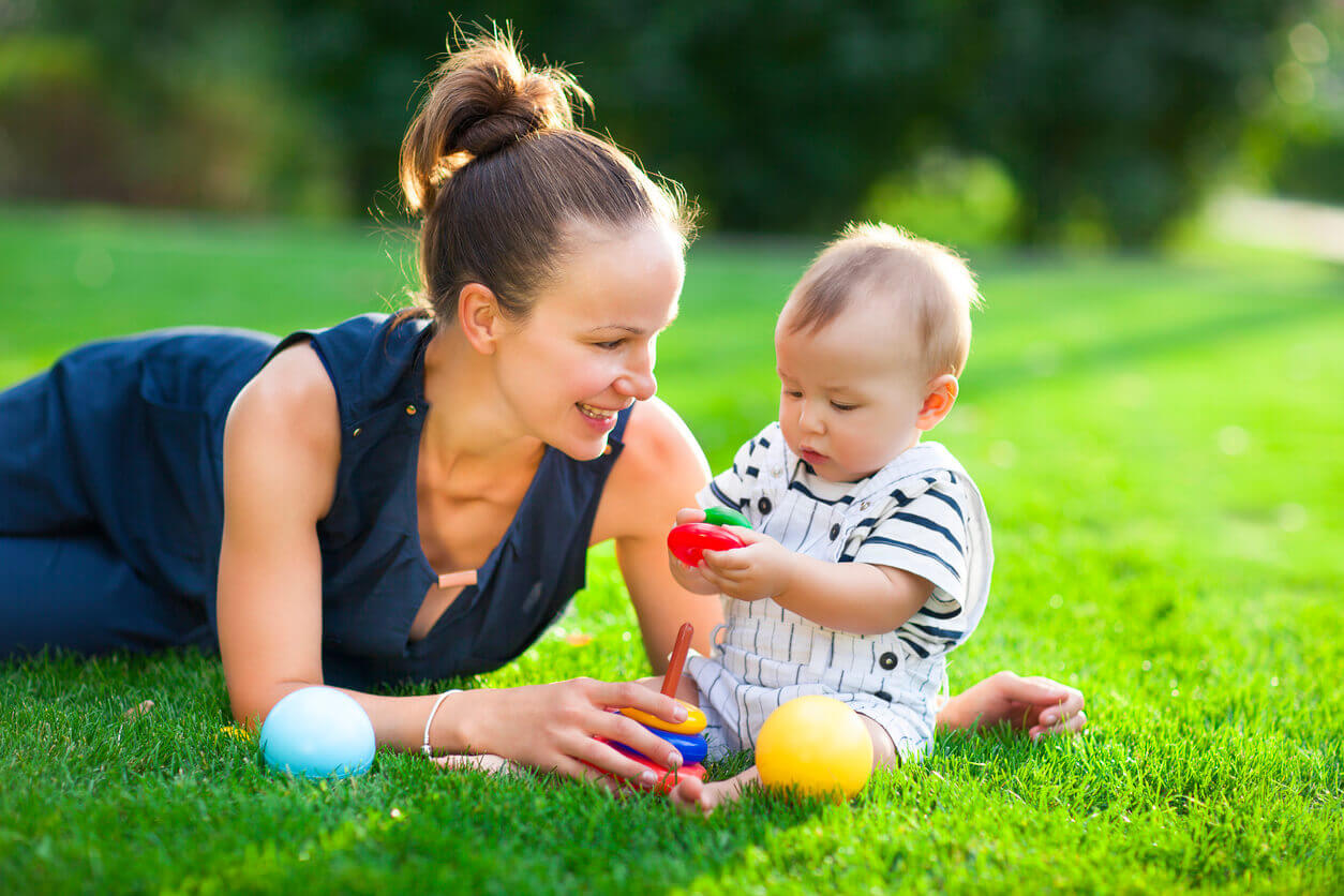 Een moeder met haar baby in het gras