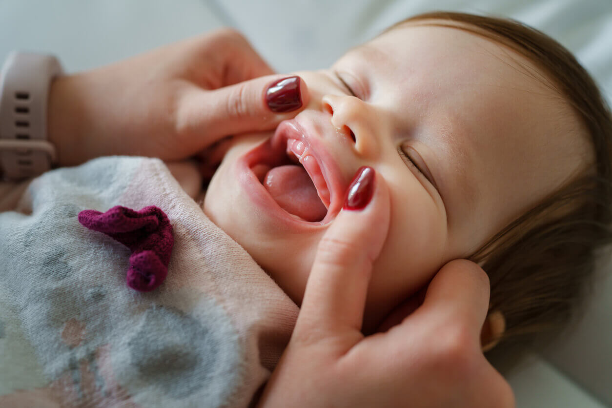 A mother looking at her baby's gums.