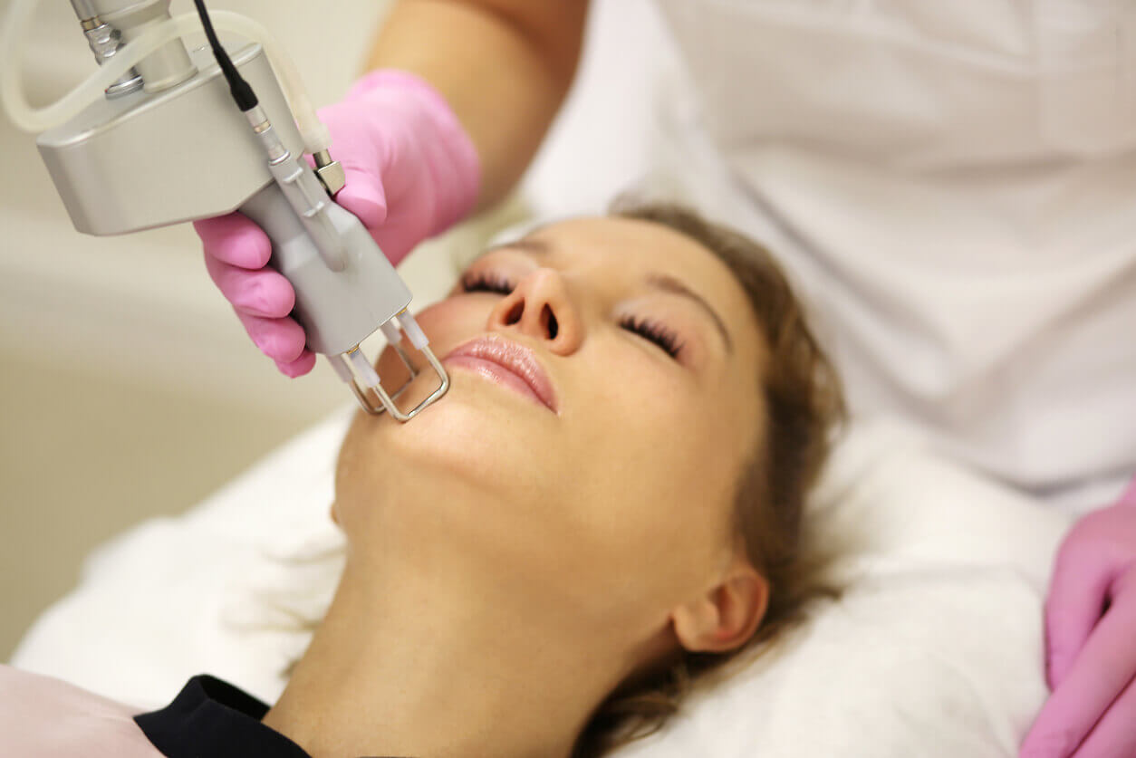 A woman undergoing dermatological treatment to remove dark spots from her face.