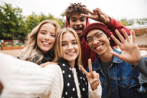  A group of teens taking a selfie outdoors.