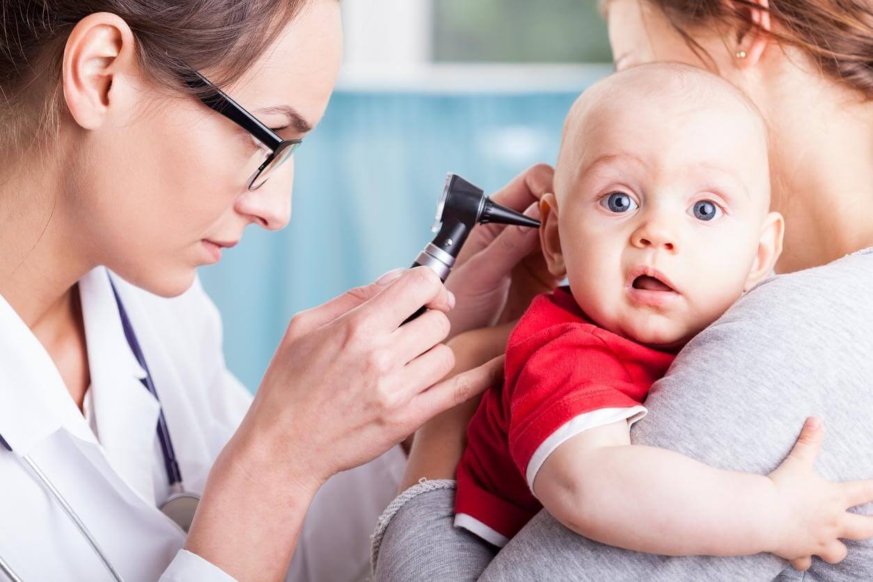 A doctor checking a baby's ears.
