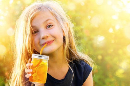 A child drinking natural flavored water from a straw.