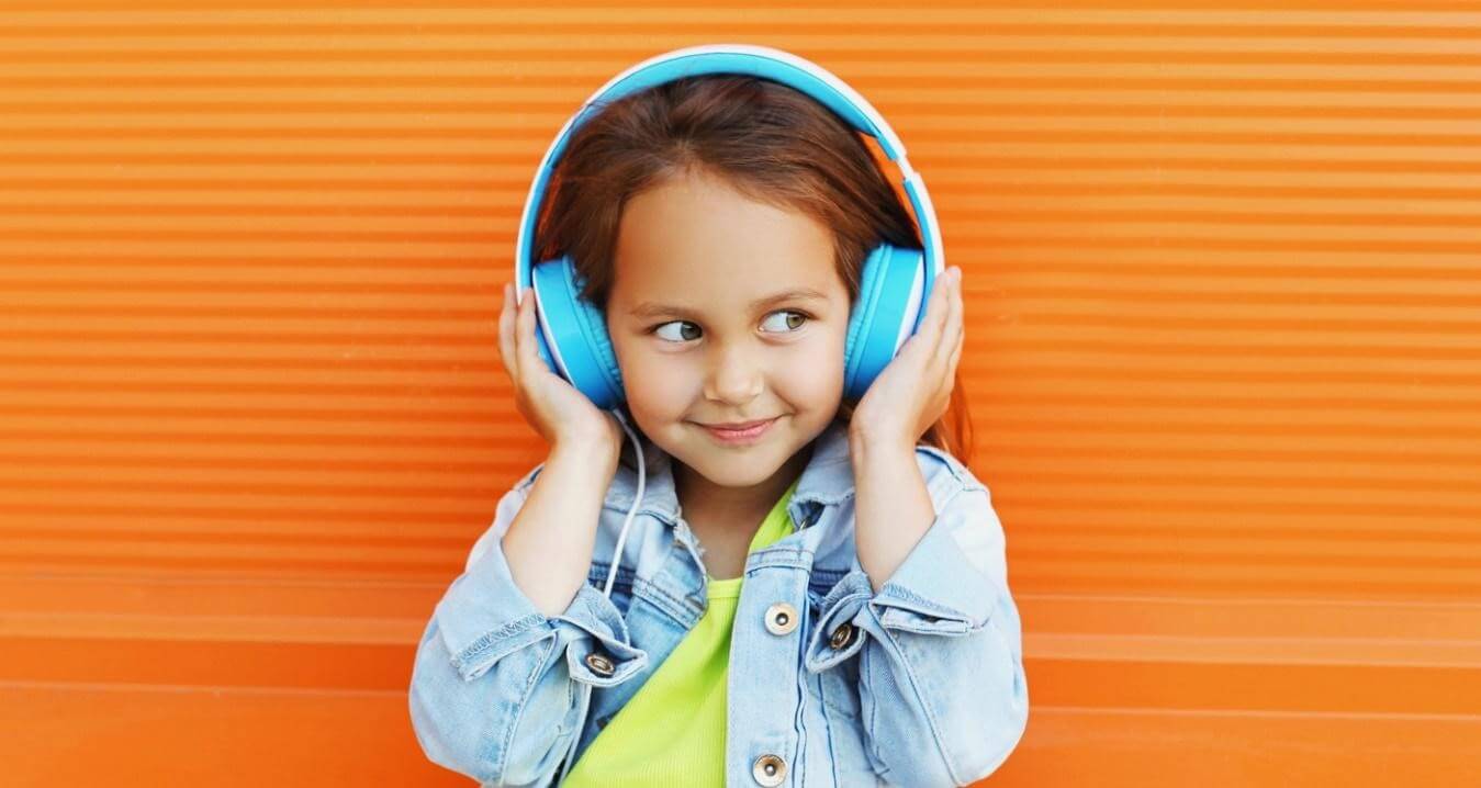 A little girl listening to headphones.