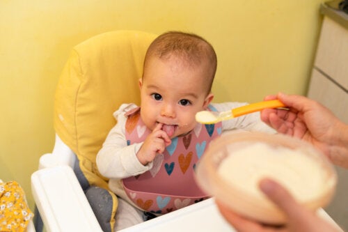 A person feeding baby cereal to a baby.