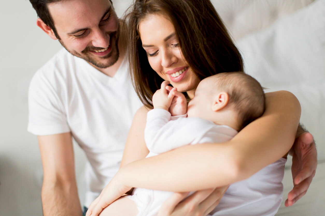 Parents smiling at their baby.