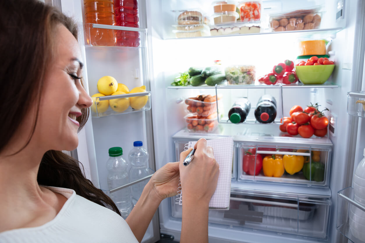 En kvinna som organiserar sitt kylskåp.
